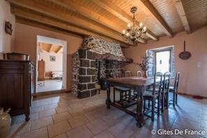 Cozy gathering space with a traditional stone fireplace, wooden dining table, and elegant touches.