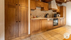 Una cocina con gabinetes de madera, salpicadero de azulejos y horno empotrado.