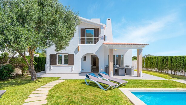 A modern two-story house with a swimming pool, a covered patio, and a stone pathway leading to the entrance.