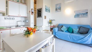 A compact living space with a kitchenette, a dining area, and a sofa. - Holiday Home "Villetta Duplex Breathtaking View" with Sea View, 2 Private Terraces and Wi-Fi (Costa Paradiso)