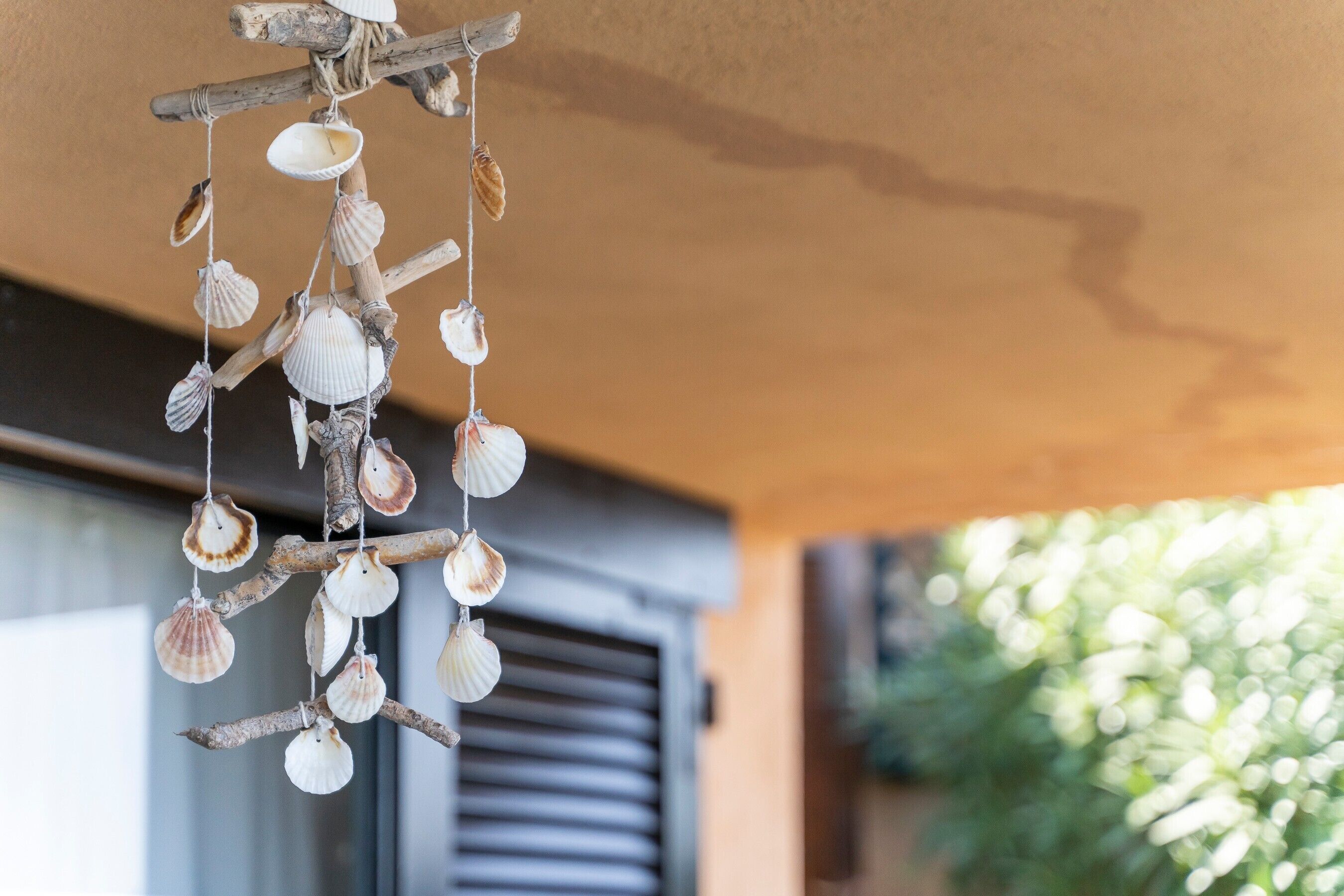 A hanging shell decoration made of shells and wood.