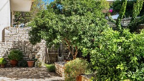 Un patio empedrado con plantas en macetas y un muro de piedra.
