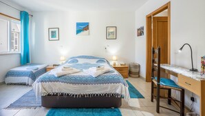 A bedroom with a bed, two bedside tables, a desk, a chair, and a window with curtains. - Holiday Home "Casa Da Paz" with Sea View, Private Terraces & Wi-Fi (Salema)