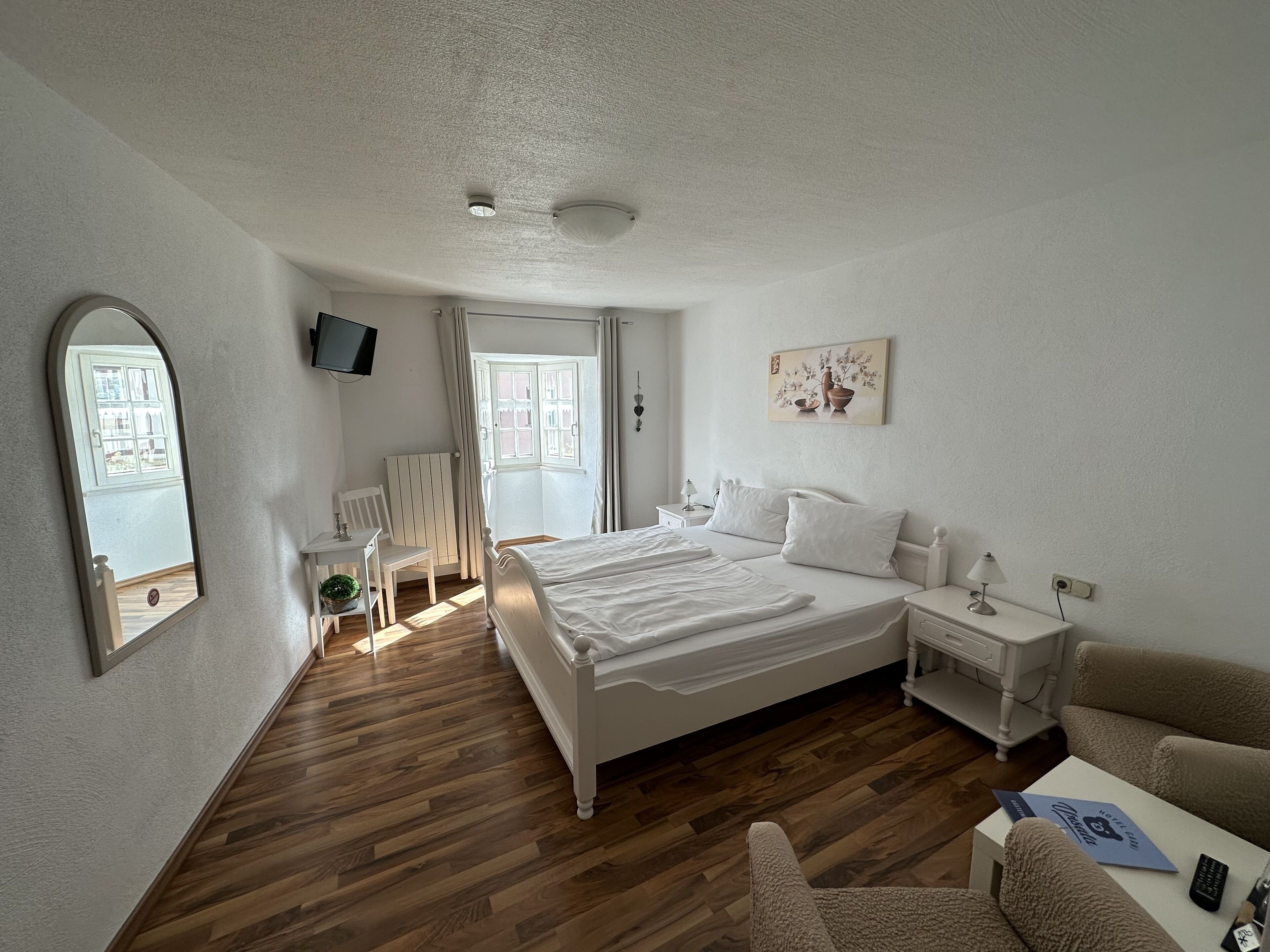 Un'ampia camera da letto con un letto grande, una scrivania, una sedia e una televisione.