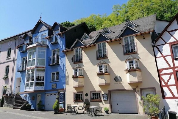 Eine Reihe traditioneller europäischer Gebäude mit vielen Fenstern und Balkonen, einige davon bepflanzt.