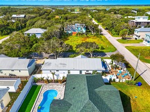 A residential area with houses, a swimming pool, and a view of the ocean. - 2 min walk to Beach, 2 King BR, Private Deck, Hot Tub, Grill & Fire Pit, Pets OK (St. Augustine)