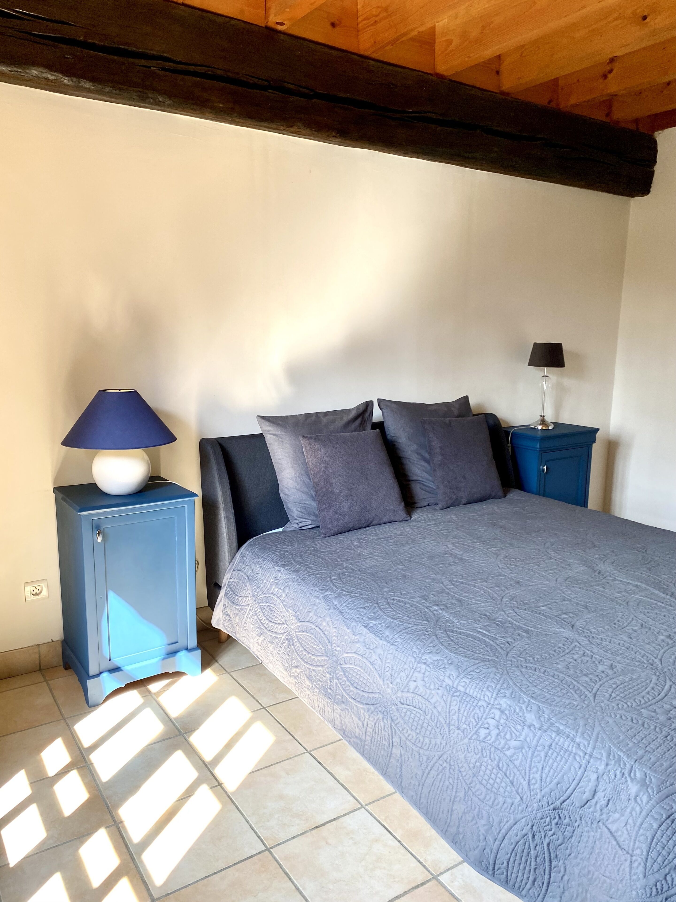 A bedroom with a bed, two nightstands, and a wardrobe.