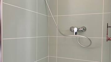 Un baño con ducha, inodoro y lavamanos.