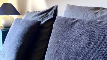 A bed with two pillows and a lamp on a bedside table.