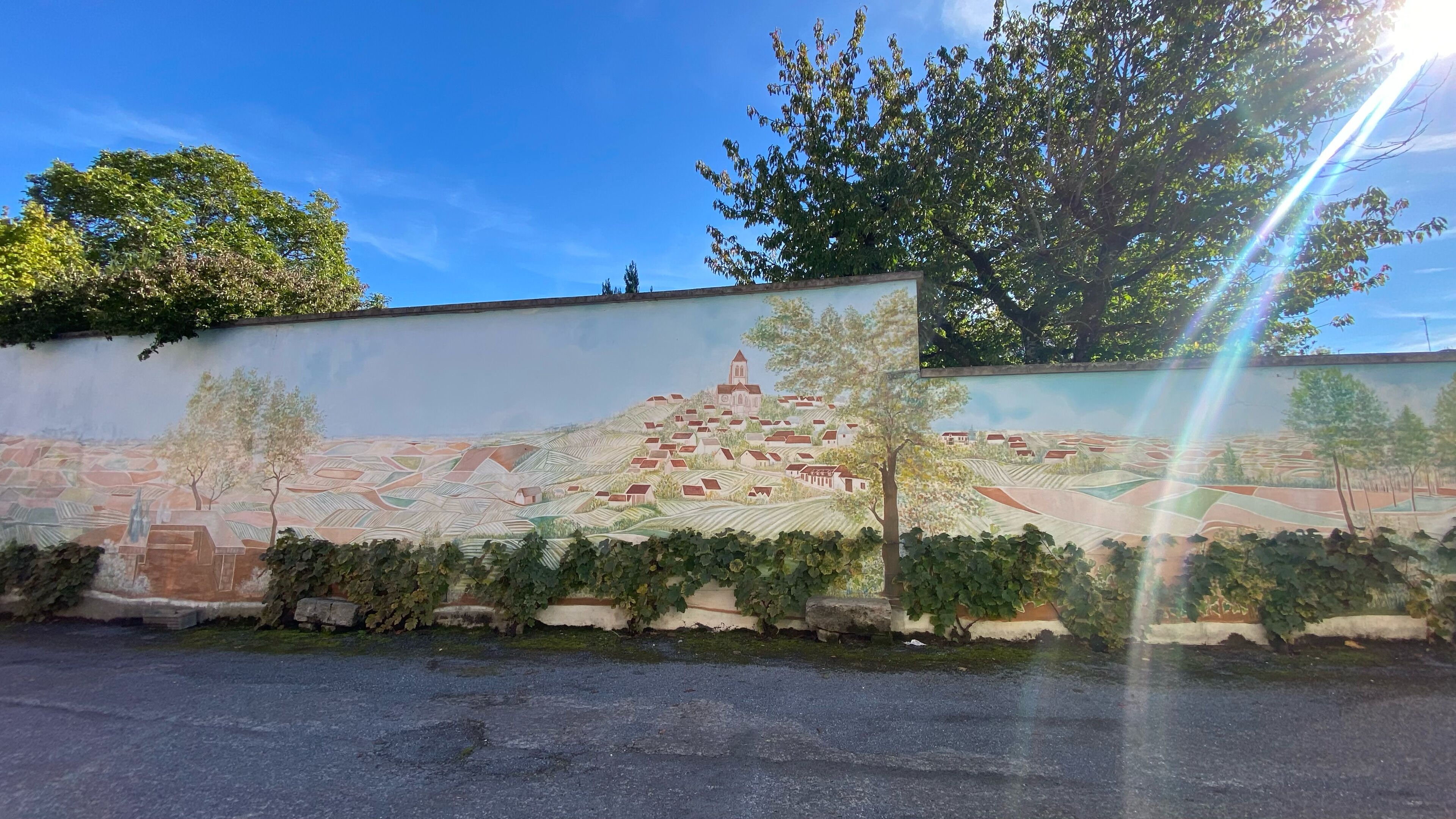 A mural of a village with houses and a church on a wall.