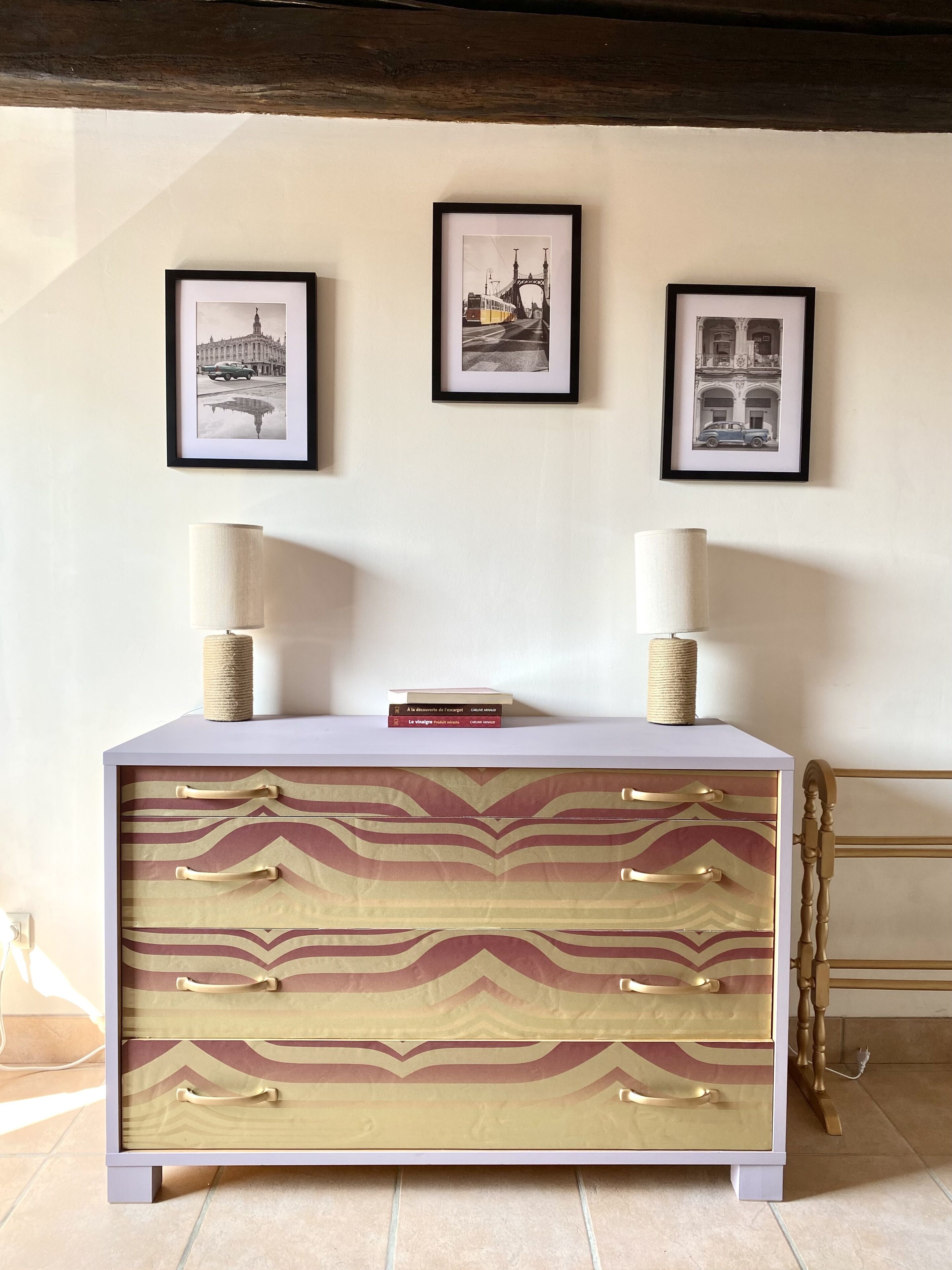 A reception desk with three framed photographs above it, a lamp on each side, and a book on top.