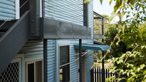 A two-story building with a balcony and a staircase. - The Mullet - With Water Views (Nambucca Heads)