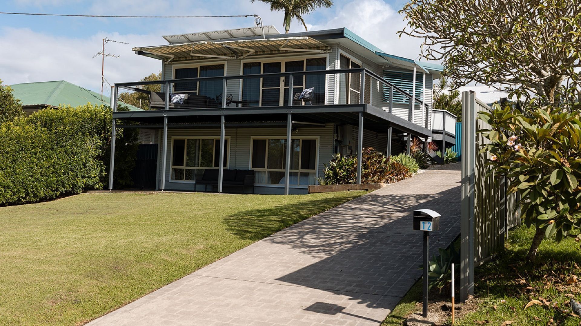 A two-story house with a covered porch and a paved driveway.