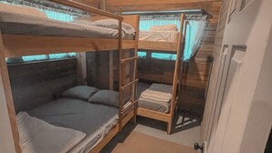 Una habitación pequeña tipo cabaña con literas y un ventanal.