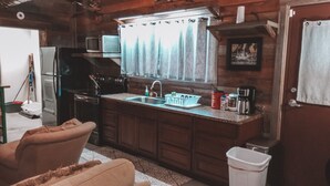 Cocina compacta con fregadero, estufa y microondas.