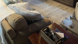Una sala acogedora con suelo de madera, un sofá, un sillón y una mesa de comedor con sillas.