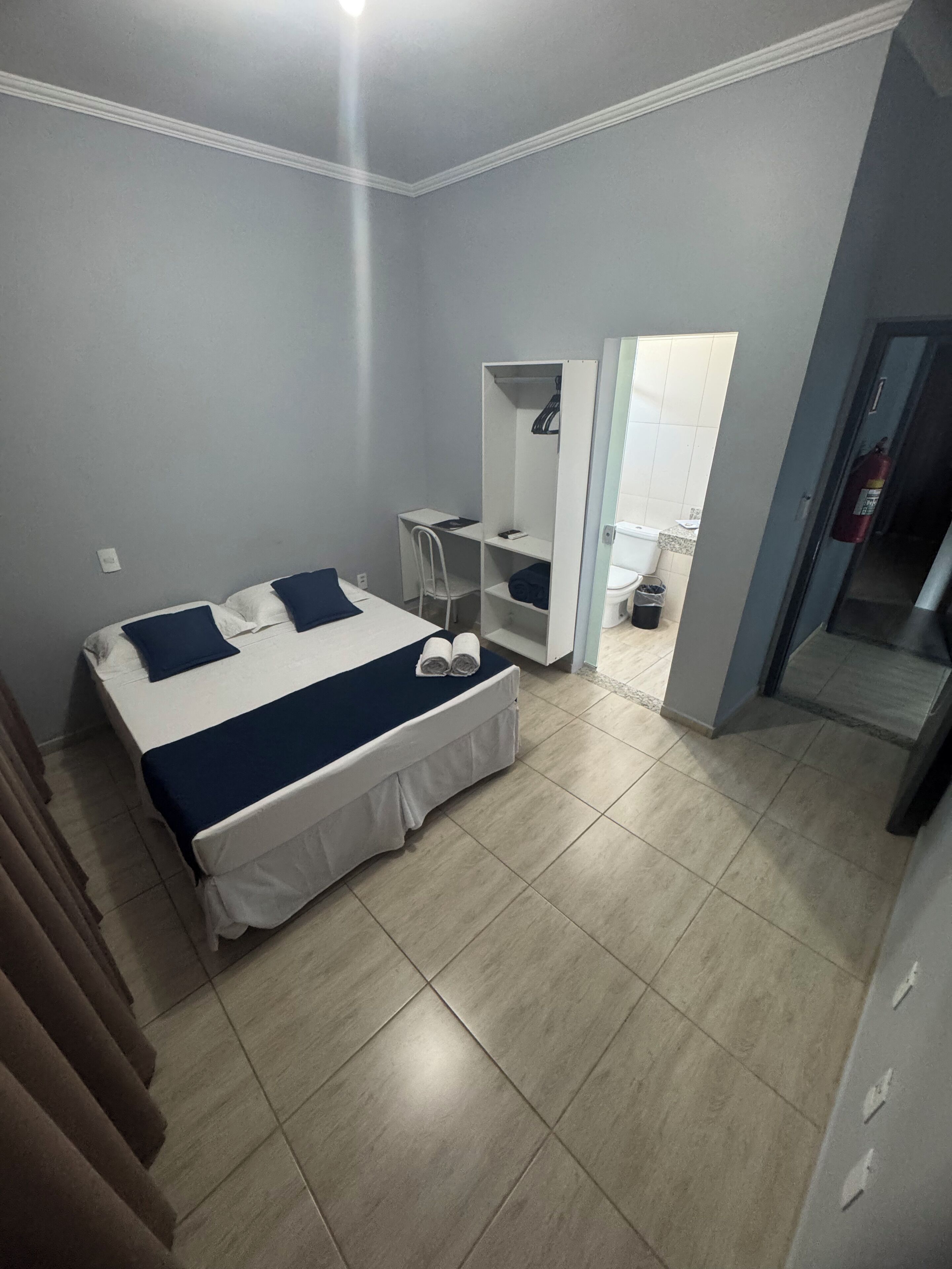 Un dormitorio con cama, escritorio y armario.