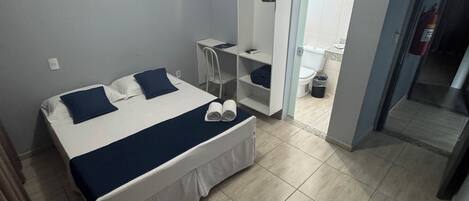 Un dormitorio con cama, escritorio y armario.
