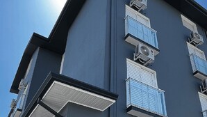 Een modern gebouw met meerdere balkons en airconditioningsinstallaties.