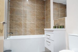 Bañera, secador de pelo, toallas y champú