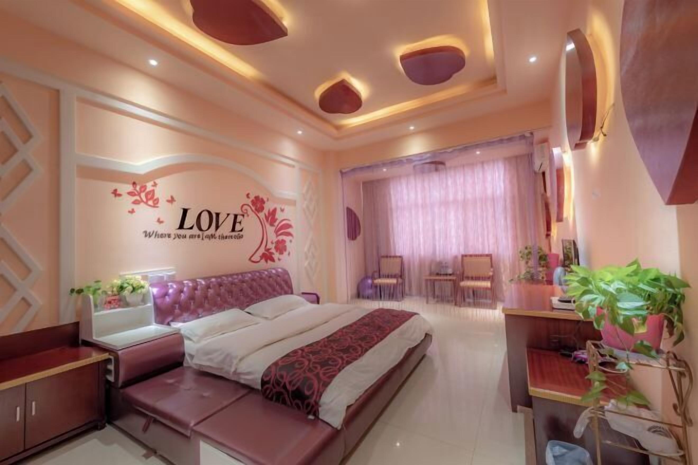 A bedroom with a bed, bedside tables, a desk, and a chair.