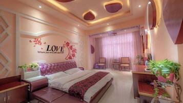 A bedroom with a bed, bedside tables, a desk, and a chair.