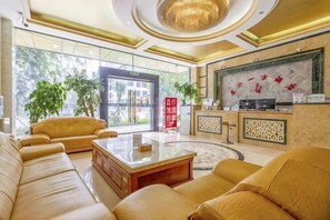 A hotel lobby with leather sofas, a coffee table, a reception desk, and large windows. - Zai Shui Yi Fang Hotel (Qiubei Jiaolian Plaza) (Qiubei)