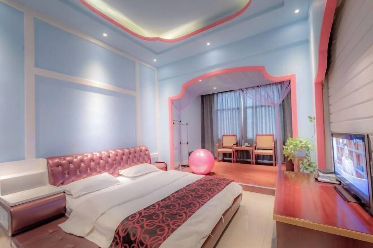 Een moderne hotelkamer met een groot bed, een bureau, een stoel en een televisie.