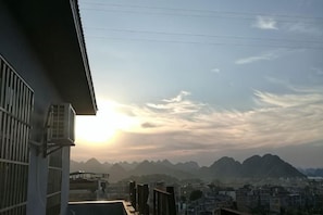Un immeuble résidentiel offrant une vue sur les montagnes lointaines et un ciel dégagé.