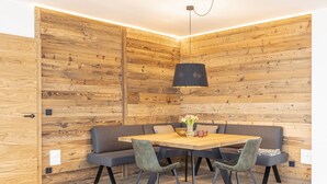A cozy room with a wooden wall, a wooden dining table, and a black pendant light. - Penthouse for up to 8 people & infinity pool (St. Martin am Tennengebirge)