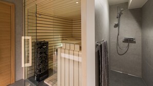 A modern bathroom with a glass shower enclosure, a built-in toilet, and a visible storage unit with a 'helo' logo. - Luxury gateway in Kranjska gora (Jesenice)