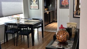 Un comedor con una mesa y sillas, un globo terráqueo, libros y una cocina al fondo.