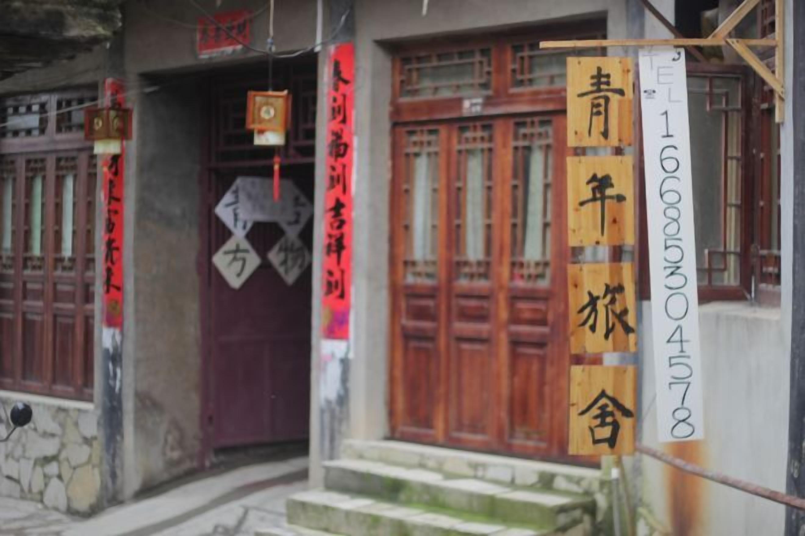 Un bâtiment doté de portes en bois de style traditionnel et d’une enseigne avec des caractères chinois.
