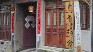Un bâtiment doté de portes en bois de style traditionnel et d’une enseigne avec des caractères chinois.
