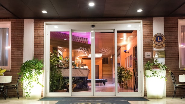 A hotel entrance with a dark carpeted staircase leading to a glass door entrance. - HOTEL GIALLETTI (Orvieto)
