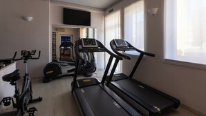 A gym with treadmills, an elliptical, and a stationary bike. - HOTEL GIALLETTI (Orvieto)