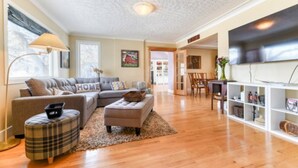 A living room with a sofa, ottoman, and a TV stand. - First Place-Family Corporate Social Gatherings
Home Away From Home. Pet Friendly (Strathmore)