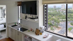 Eine moderne Küche mit großem Fenster, einem Flachbildfernseher und einer Kaffeemaschine.