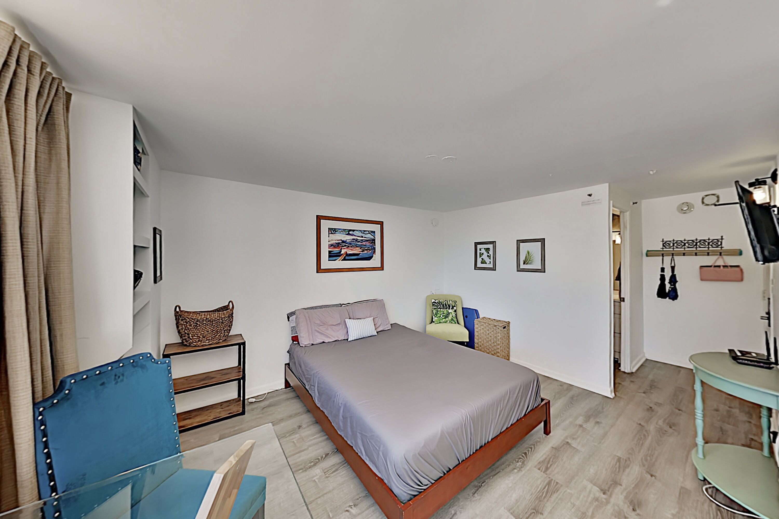 Une chambre à coucher avec un lit, une chaise, un bureau et une étagère.