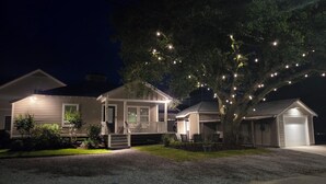A residential property with a two-story house, a covered porch, and a garage. - "Lil House" Cozy 2-bedroom cottage walking distance to beach and downtown. (Bay St. Louis)