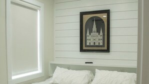 A bedroom with a bed, a ceiling fan, a window, and a framed picture on the wall. - "Lil House" Cozy 2-bedroom cottage walking distance to beach and downtown. (Bay St. Louis)