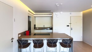 A modern kitchen with a central island, built-in appliances, and a minimalist design. - Pines Belle - Two Bedroom Apartment, Sleeps 4 (Tel Aviv-Yafo)