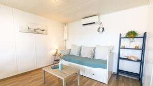 Una sala de estar moderna con un sofá, una mesa de centro y una estantería.