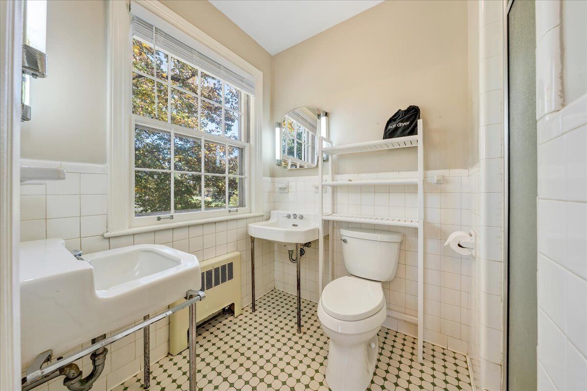 Un baño con lavamanos, inodoro y ventana.