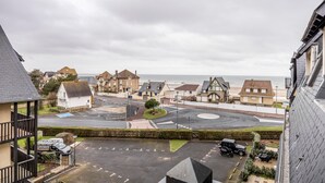 Ett bostadsområde vid kusten med hus, en rondell och en strand i bakgrunden.
