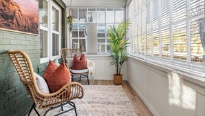 Une pièce chaleureuse avec un fauteuil en osier, une petite table et une plante en pot.