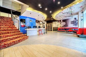 A modern interior with a staircase, a bar area, and a large wall with artwork. - Palon Hotel (Chongqing Xinpaifang) (Chongqing)