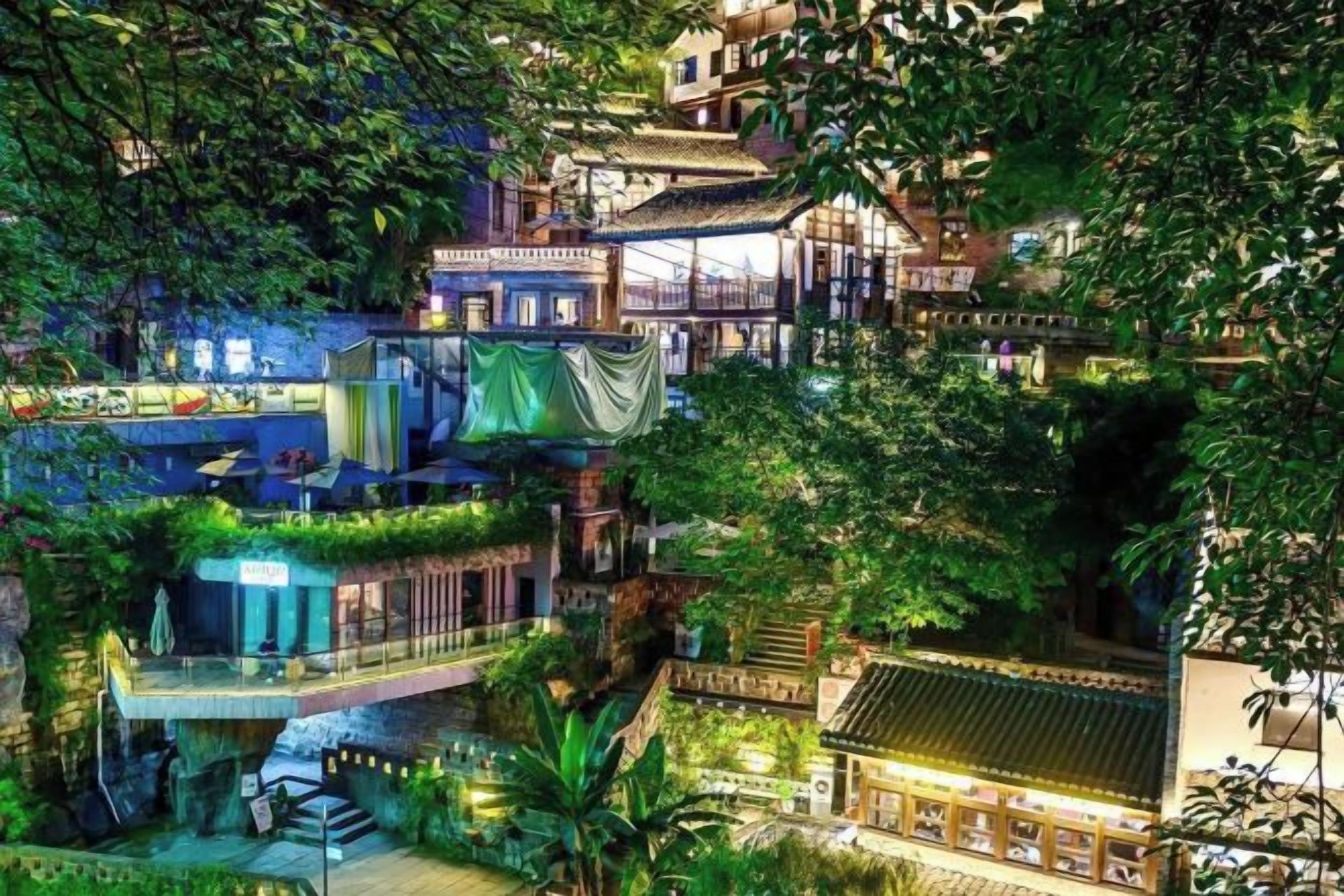 A multi-level building with terraces and balconies, surrounded by lush greenery.