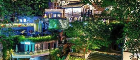 A multi-level building with terraces and balconies, surrounded by lush greenery.
