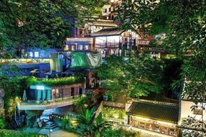 A multi-level building with terraces and balconies, surrounded by lush greenery. - Palon Hotel (Chongqing Xinpaifang) (Chongqing)